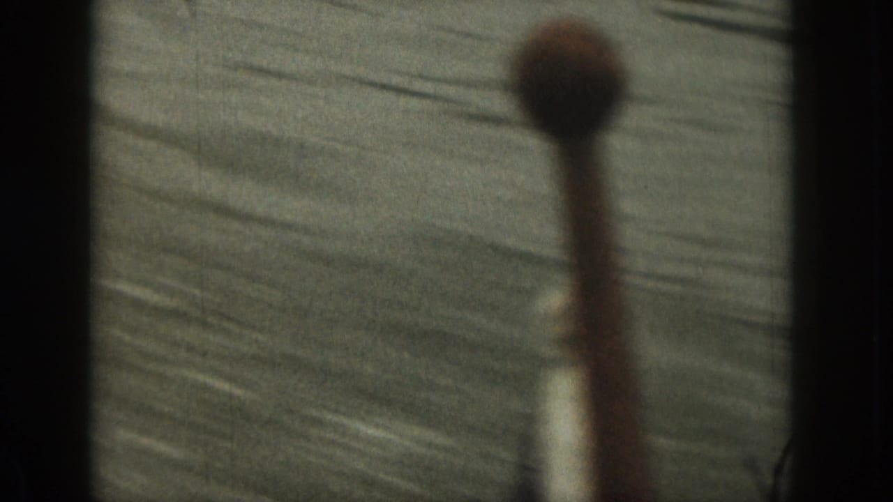 1961 Michigan home-movie frame with rippling water and an out-of-focus foreground object, likely filmed from a moving boat.