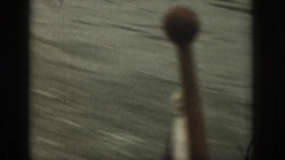 1961 Michigan home-movie frame with rippling water and an out-of-focus foreground object, likely filmed from a moving boat.