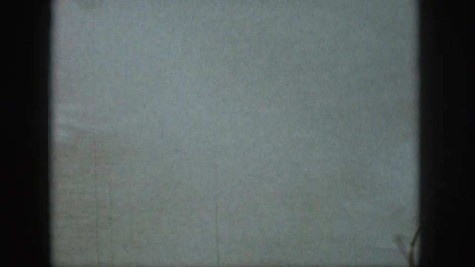 Soft 8mm frame from the Michigan lake sequence, dominated by pale water spray and blurred lake surface.