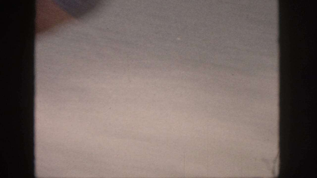 Blurred lake surface with dark film gate edges and little visible action.