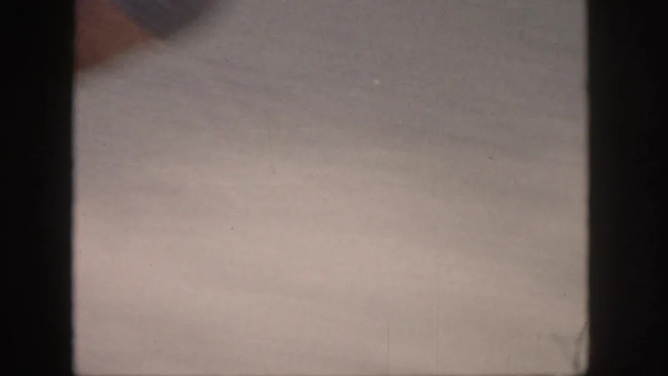 Soft 8mm frame from a Michigan lake scene, mostly water and film-frame edges with action outside the visible area.