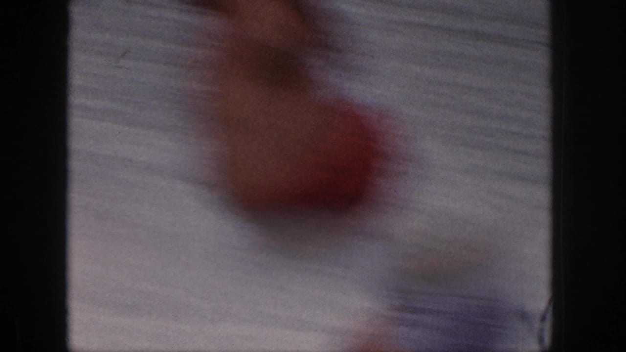 Blurred close view of the skier falling or passing near the camera frame.