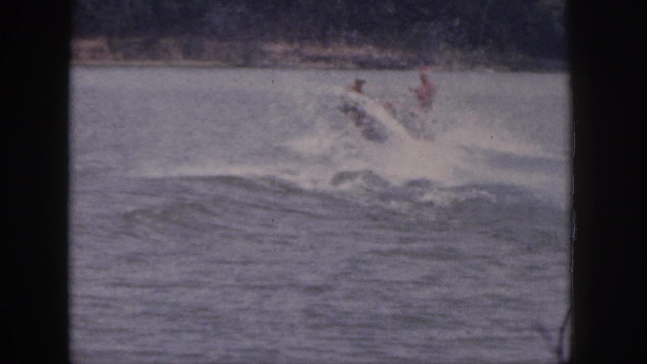 Water skier crashes into the lake with a splash near the right side of the frame.