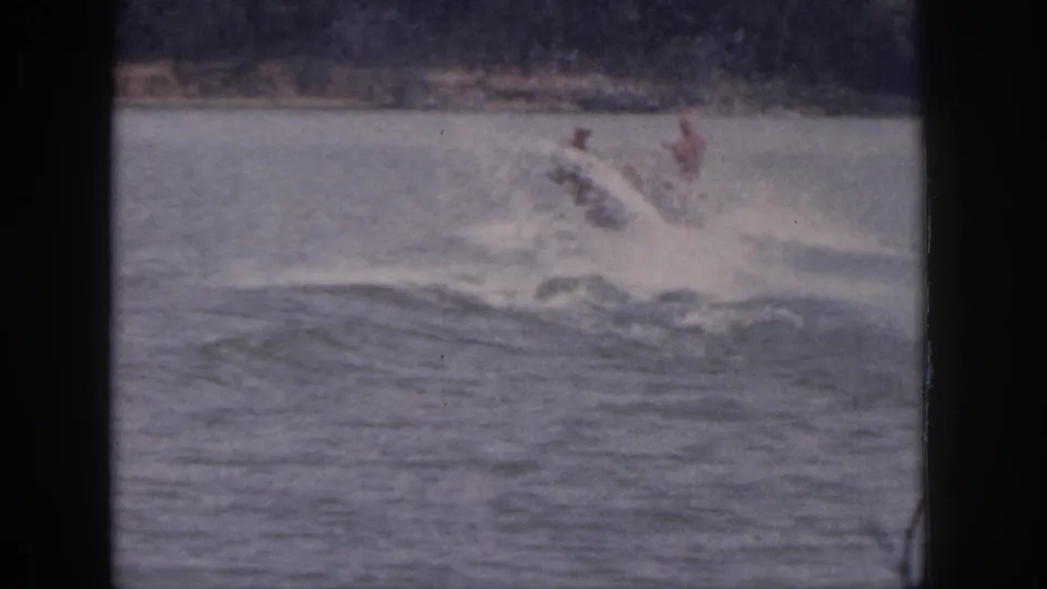 1961 Michigan 8mm frame capturing the skier losing balance and splashing into the lake during a tow run.