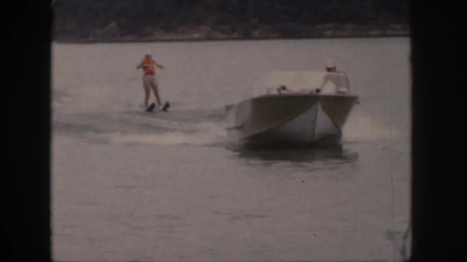 The skier appears to lose balance while following the motorboat across the Michigan lake in the 1961 8mm footage.
