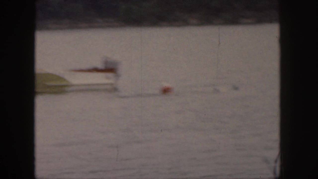 Small motorboat appears soft and blurred on the lake with a float nearby.