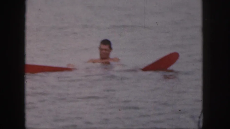 A man is visible in the Michigan lake water near red boat or buoy parts after falling from the small motorboat.