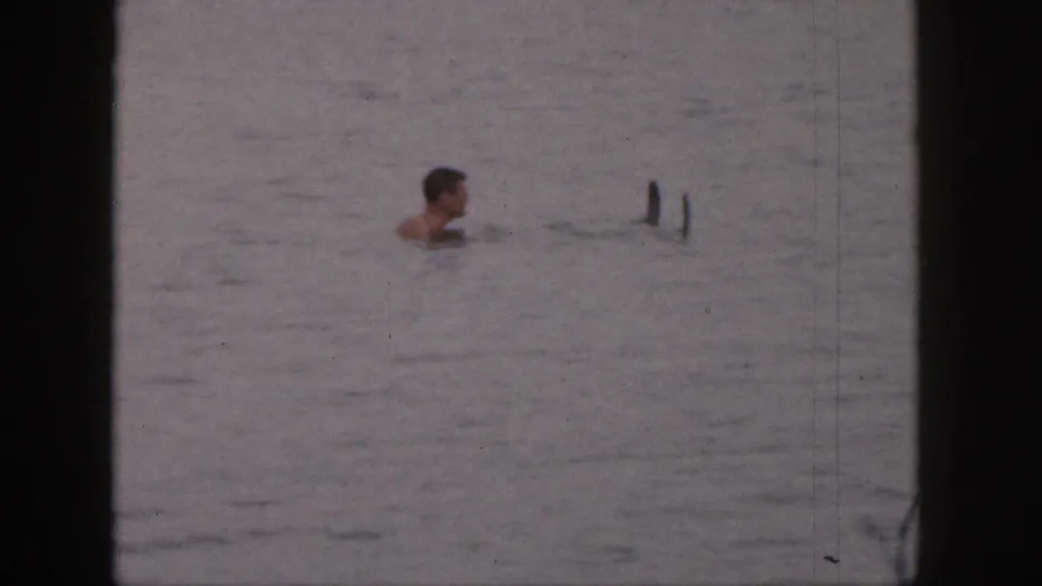 The final frame shows the man farther from the camera in open water, with board tips or submerged gear visible nearby.