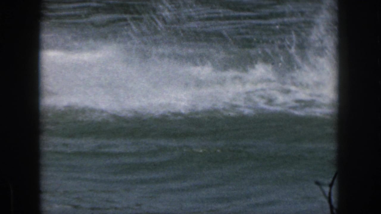 1961 Michigan 8mm frame showing choppy lake water, white wake, and dark scan borders with no clear person in view.