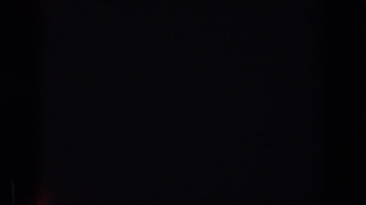 A mostly black 8mm frame from the 1961 Michigan clip, with little visible subject detail and dark gate borders.