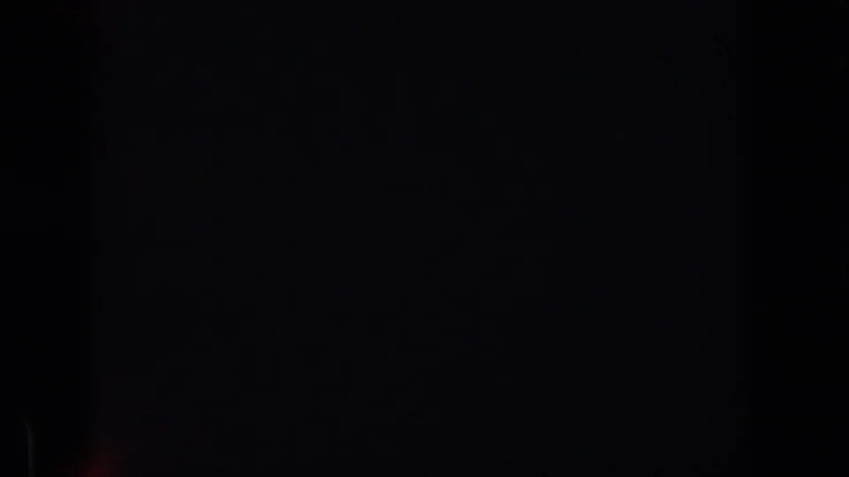 A mostly black 8mm frame from the 1961 Michigan clip, with little visible subject detail and dark gate borders.
