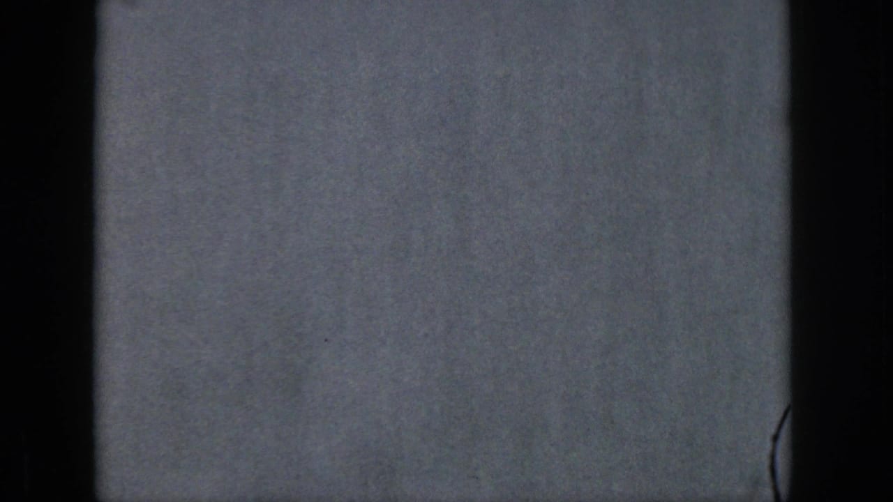 A gray-blue exposed or blank 8mm frame appears between water skiing shots, with dark film borders and visible film texture.