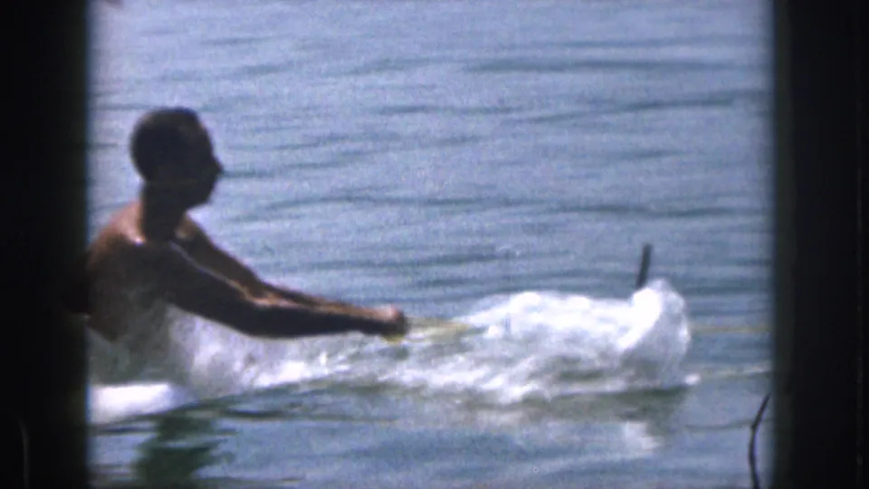The adult skier appears to lose balance and fall into the Michigan lake, with white spray and a water ski visible beside him.