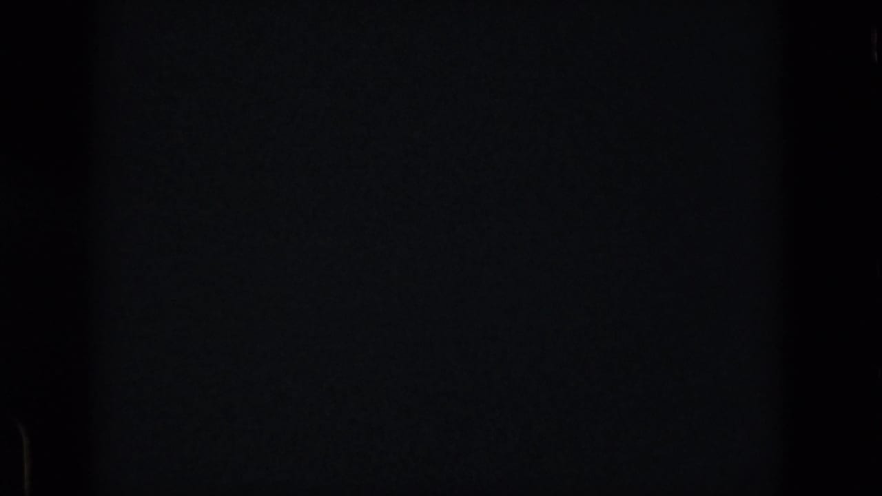 Blank or obscured opening frame from the 8mm clip, showing dark exposure and minimal visible detail before the lake scene appears.
