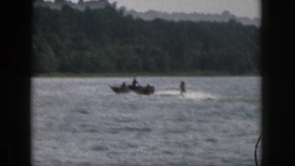 1961 Michigan 8mm frame showing a motorboat pulling a water skier over the lake surface.