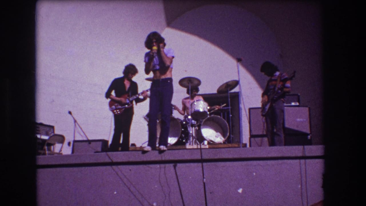 Band continues performing on stage as the singer holds the microphone near center.