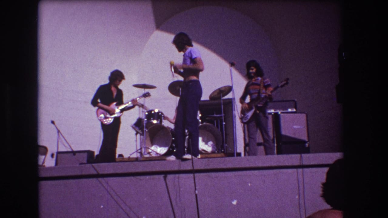 Band members on stage as the vocalist looks down and musicians adjust instruments.