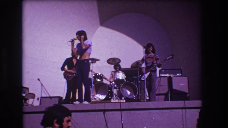 Final 1973 Medford 8mm frame shows the band playing from an audience perspective, with the singer near center and musicians across the stage.