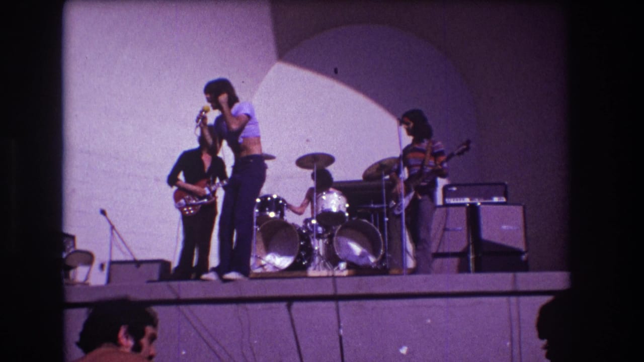1973 Medford, New Jersey concert frame with the singer facing the microphone, guitarists on either side, and drums centered behind.