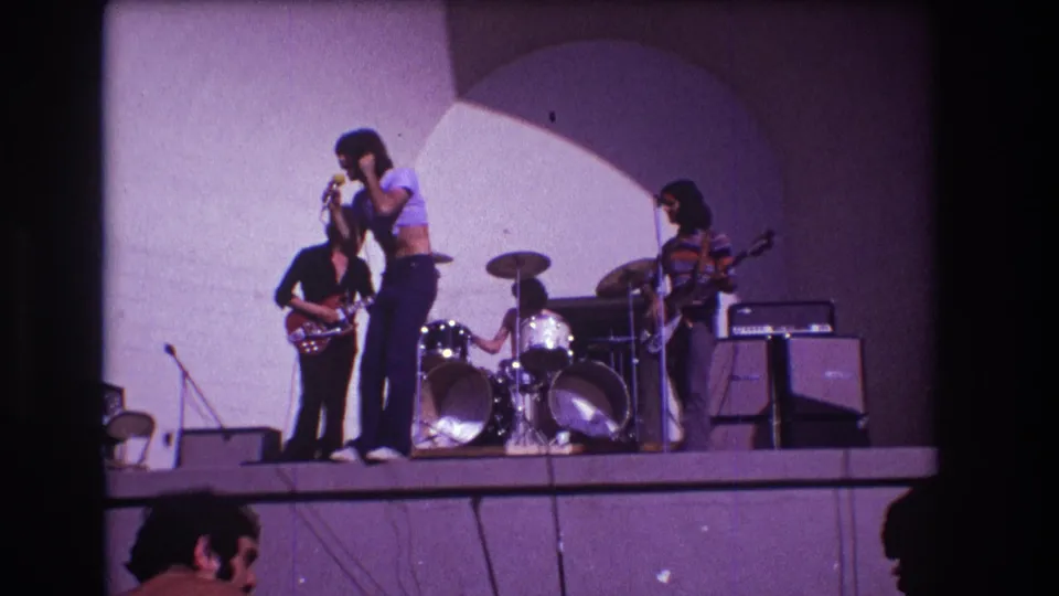 1973 Medford, New Jersey concert frame with the singer facing the microphone, guitarists on either side, and drums centered behind.