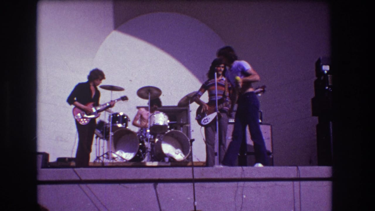 1973 Medford, New Jersey 8mm frame showing a singer, drummer and two guitarists on a raised stage.