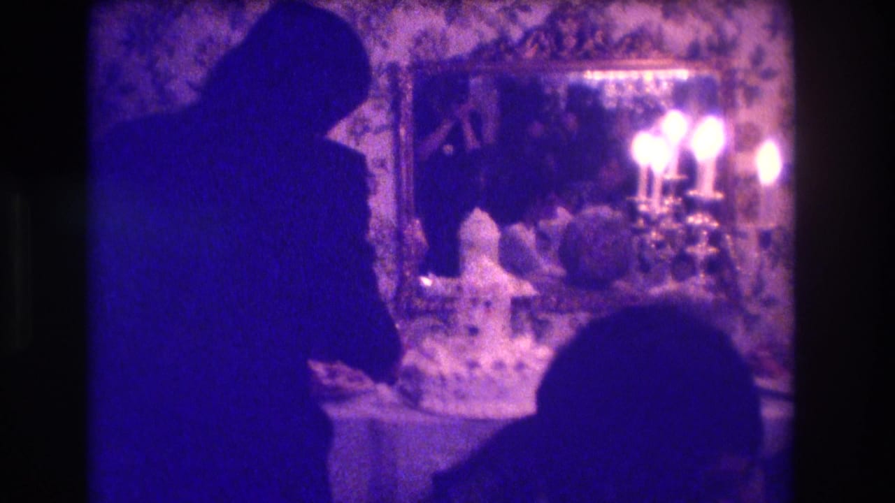 1973 Medford, New Jersey 8mm frame showing silhouetted wedding figures near a cake table, candles, floral wallpaper, and an ornate mirror.