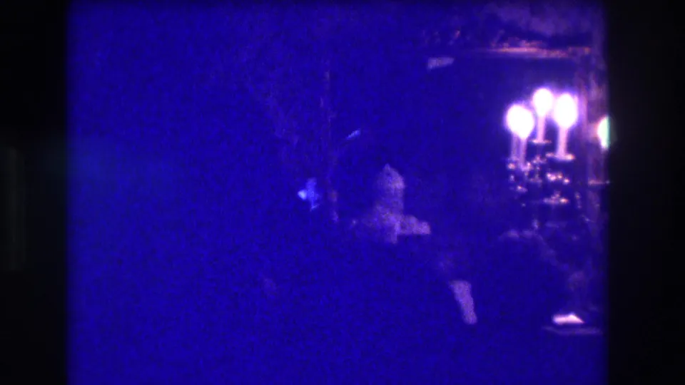 The final frame shows silhouetted people in a dim Medford interior, with bright candelabra bulbs and dense blue 8mm color shift.