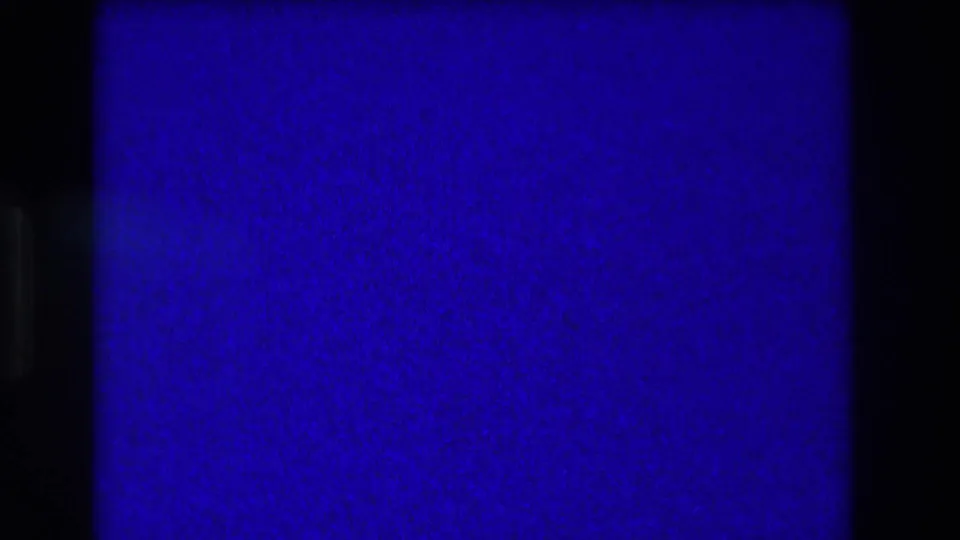 Blue-purple 8mm frame at the start of a 1973 Medford, New Jersey wedding reception clip, with no clear figures visible.