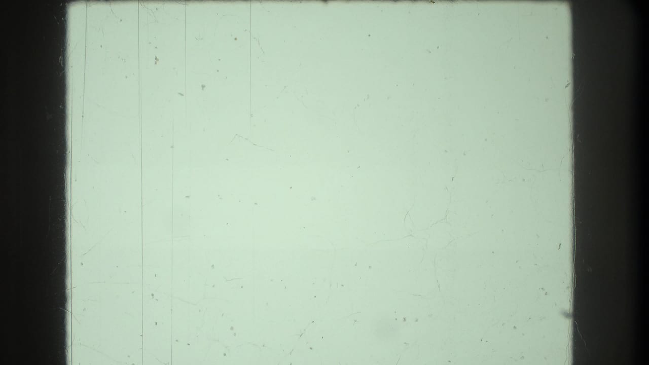 Pale mint-green overexposed film frame with faint vertical scratch marks.