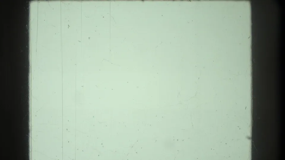Pale green overexposed 8mm frame with faint vertical scratch marks — transitional artifact in a 1973 home movie clip.