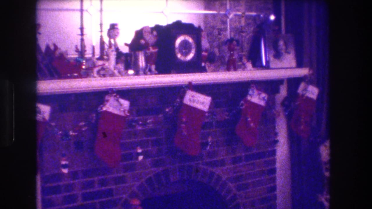 Brick fireplace with Christmas stockings and mantel decorations in a private home interior.