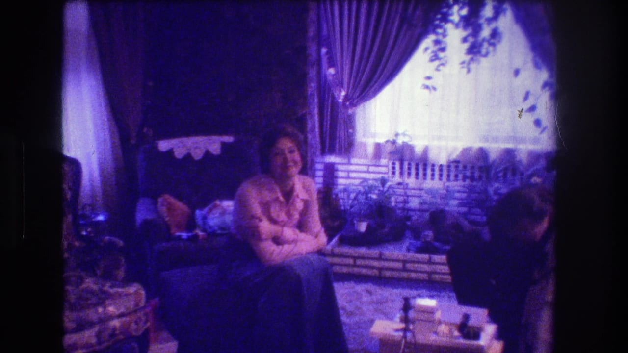 Woman seated in a living room near a curtained window during a Christmas gathering.