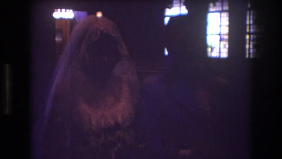 A closer 8mm frame shows the veiled bride in very low light, with the groom or another figure partly obscured beside her in the church interior.