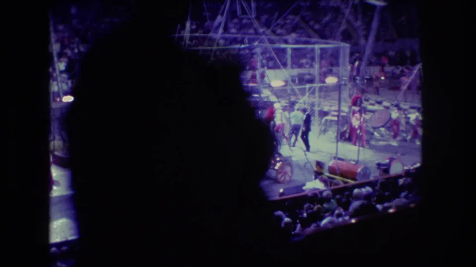 Indoor circus scene in Boston, 1974, partly obscured by a spectator silhouette, with performers and rigging visible beyond the audience area.