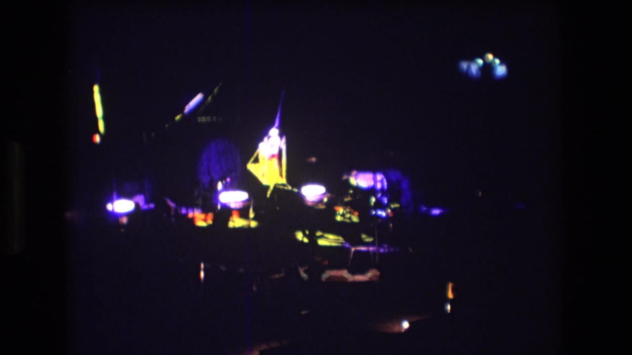 Dark circus stage with purple lighting and bright illuminated set pieces.