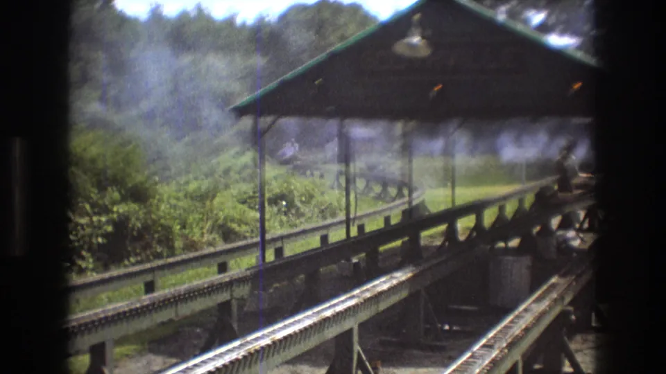 The Southville station area appears through drifting smoke or steam, with miniature rails crossing the foreground and a rider partially visible near the right edge.