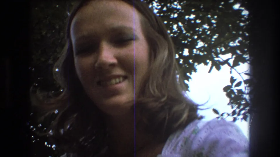 The 1975 Baxter, Maine footage ends on a close-up of the young woman smiling, framed against trees and bright sky with visible 8mm texture.