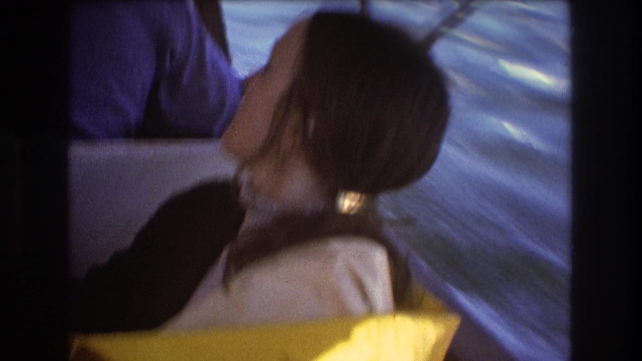 Woman in a boat turns away as water passes in the background.