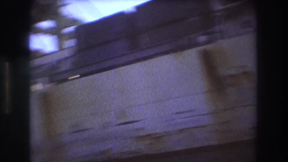 Soft, motion-blurred Boston 1975 harbor frame looking close to a ship side or dock structure, with water below and blue-purple 8mm color shift.