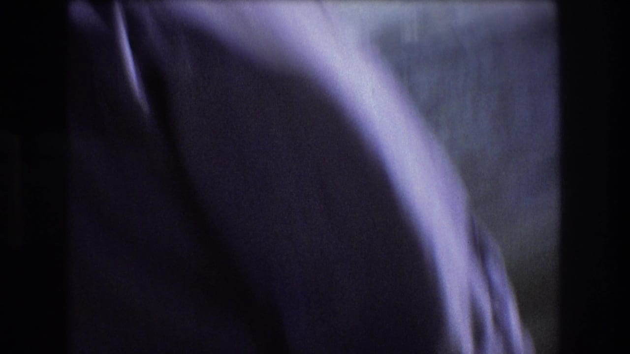 1975 Boston 8mm frame with blurred water beyond dark boat framing and a large purple-toned indistinct shape along the right side.