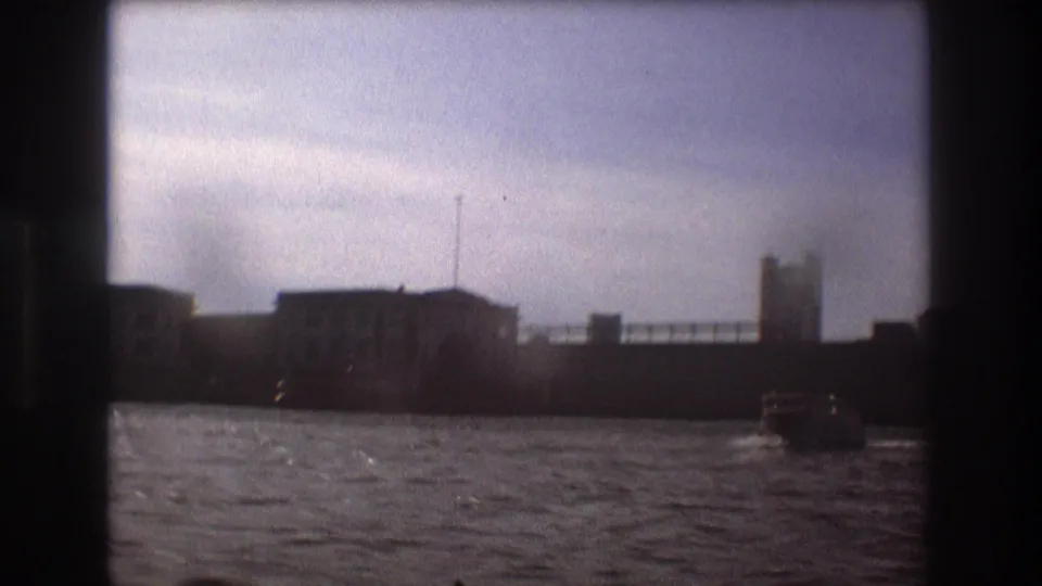 Boston waterfront structures viewed from the water in 1975 home-movie footage, with a small motorboat near the right side of the frame.