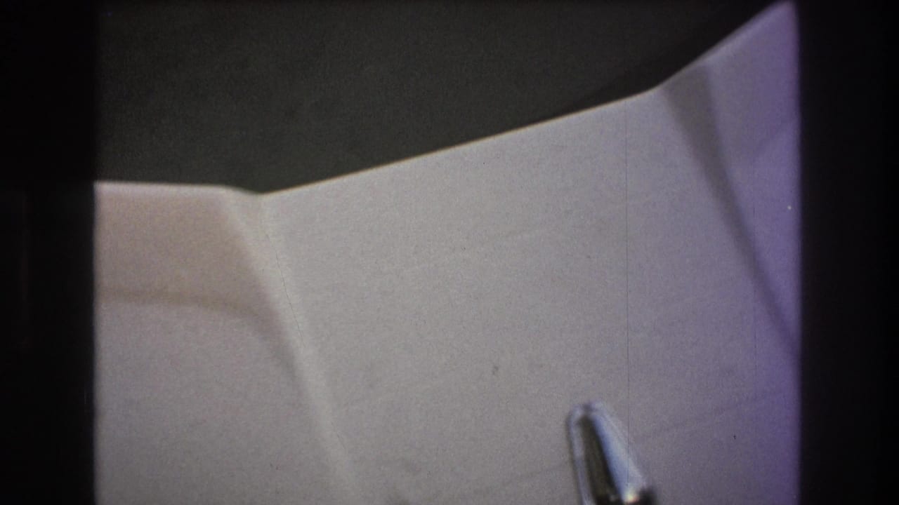 Soft 8mm frame from a 1975 Boston-area boating clip showing a white molded cabin surface, a small metal handle, and dark film-edge shadows.