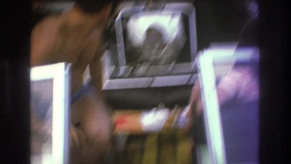 Soft, blurred 1975 Boston 8mm frame showing adults on a small motorboat with a white outboard engine and dark film-frame borders.