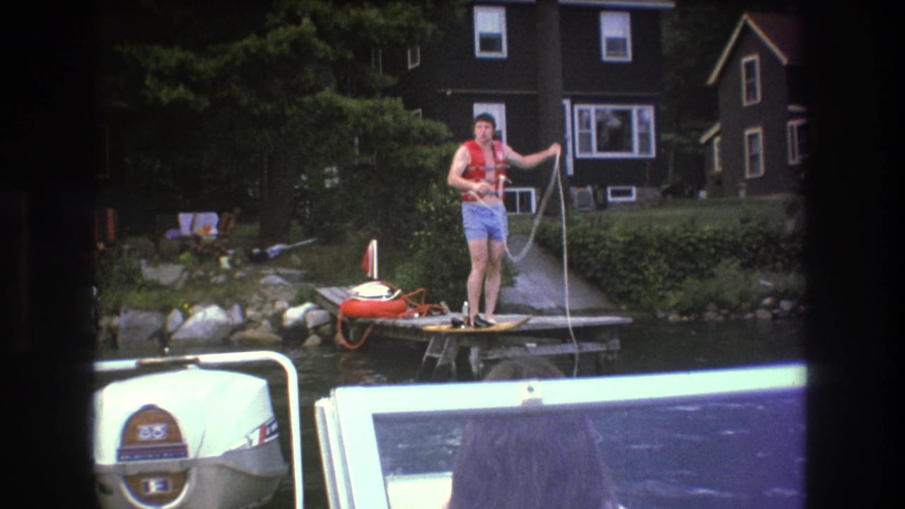 Man on a dock pulls a rope while water sprays or mist appears near the line.