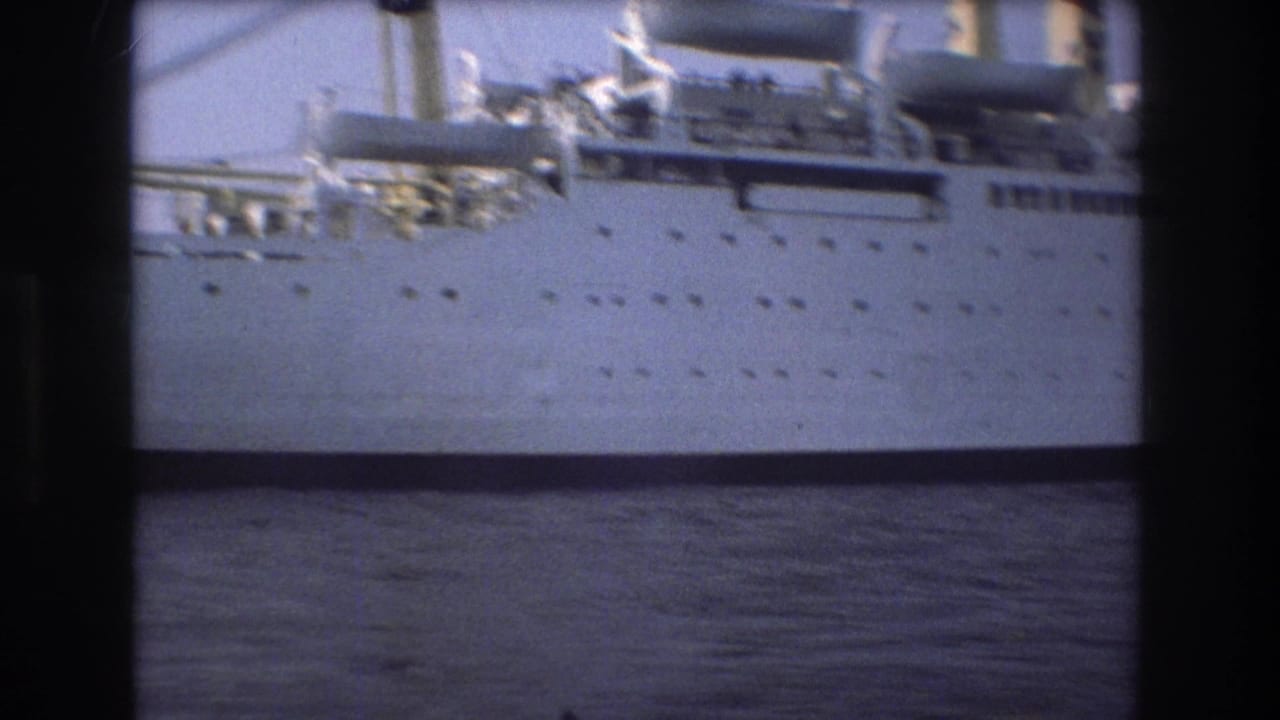 1975 Boston 8mm frame with a closer view of the ship's white hull, porthole rows, lifeboat equipment, upper deck, and dark water beneath.