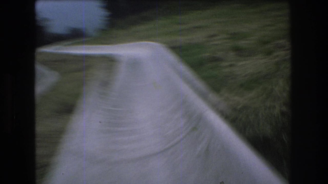 Blurred first-person view of a concrete slide bending along a grassy slope.