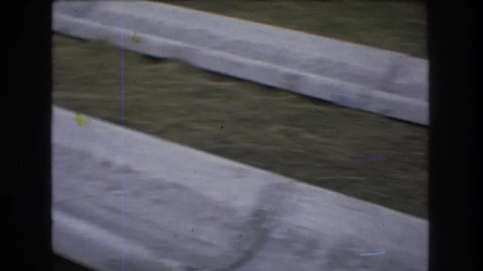 1976 Mt Bromley, Vermont 8mm frame showing a broad concrete channel in the foreground, another lane behind it, and wooded hillside surroundings.