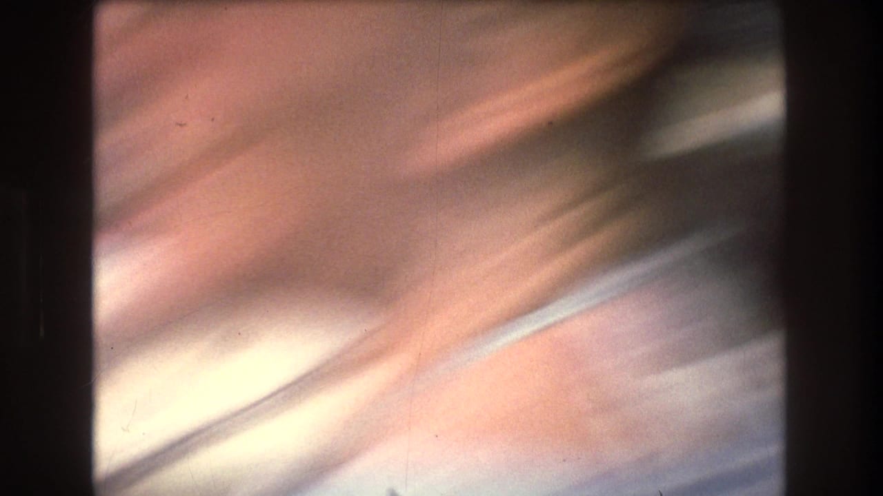 Metadata-supported 1976 8mm New York City home-movie frame with a highly blurred, tilted view of pale water or sky during rapid boat movement.