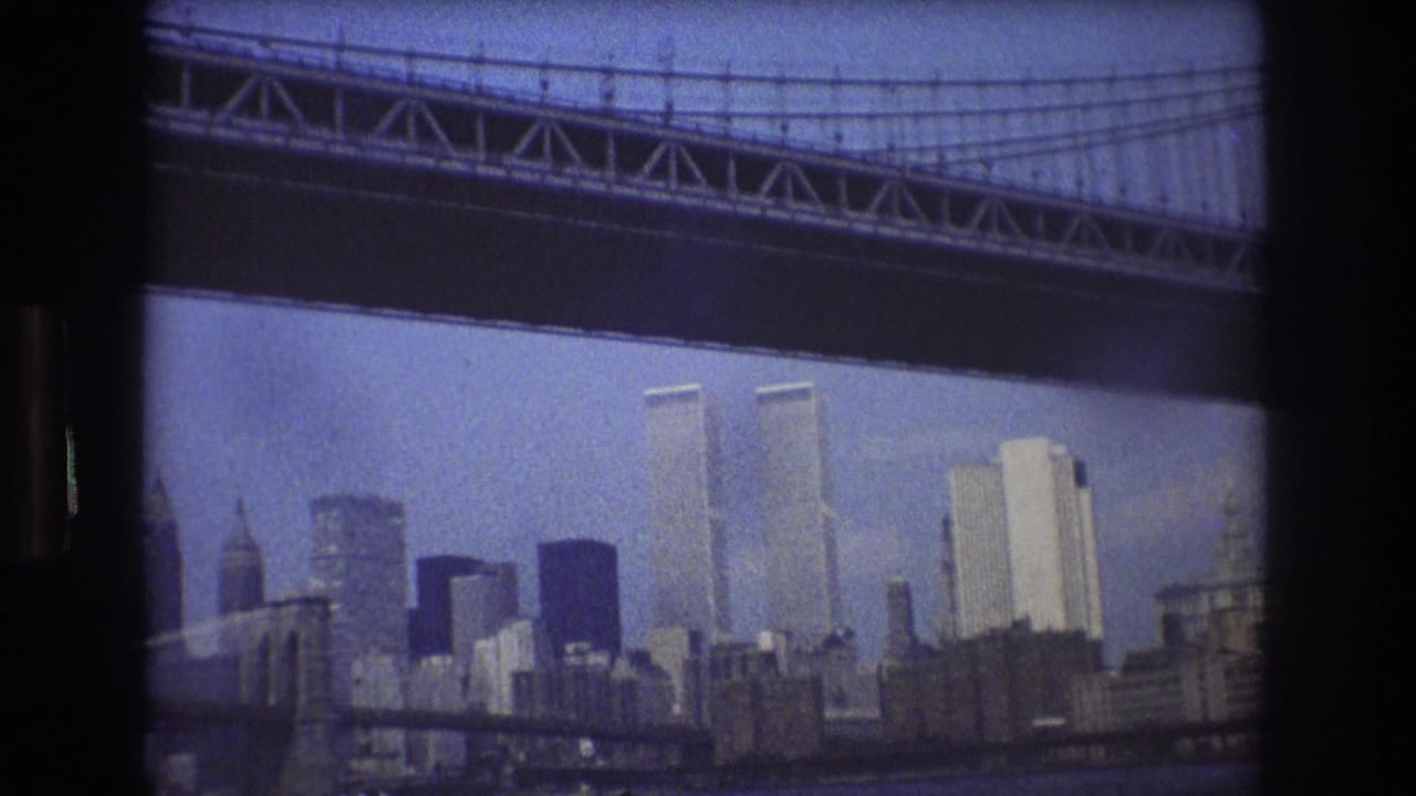 World Trade Center towers and city buildings framed by bridge steelwork over the harbor.