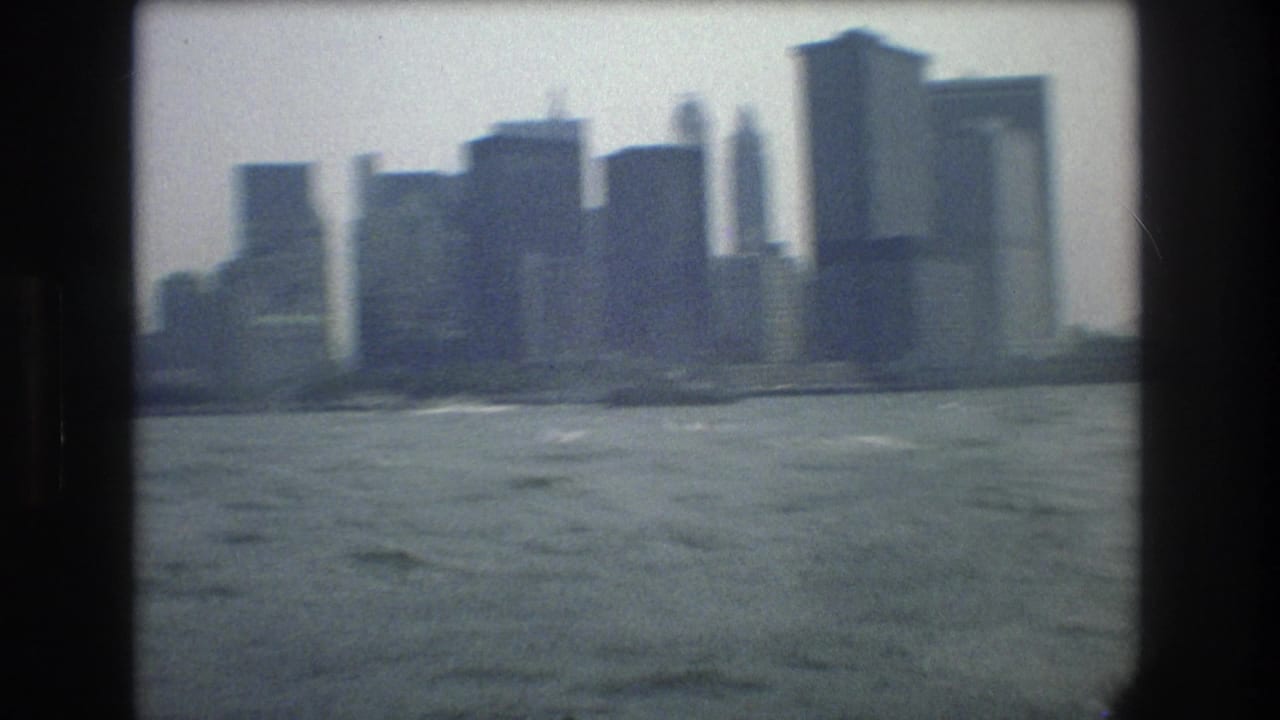 1976 8mm home-movie view of the New York City skyline seen across choppy harbor water from a moving boat.